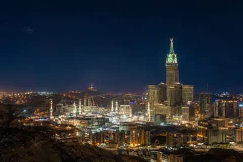 Gece vakti Mekke silüeti; saat kulesi ve Harem’in minareleri